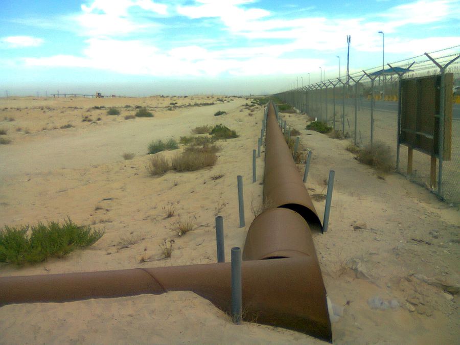 Archive: parallel crude/product oil pipelines snaking across Jubail desert scrub, Saudi Arabia, 3 Dec 2012 (Suresh Babunair, CC BY 3.0). Not the September 2026 Saudi East-West (Petroline) drone-strike damage, not the 3–5 week repair clock, not Yanbu terminal day-of, not Chris Wright’s Bloomberg TV interview, and not a live Hormuz still.