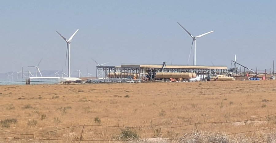 Archive photo: Fervo Energy’s Cape Station geothermal plant under construction in Beaver County, Utah, with wind turbines behind it, August 2025.